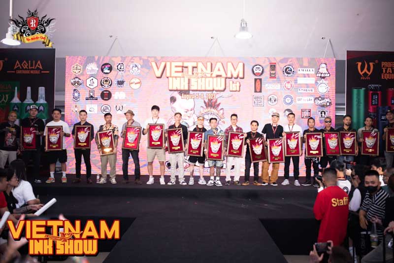 Master Artist Trieu Viet Anh honored on stage as an official judge at the Vietnam Ink Show, standing with prestigious industry experts.
