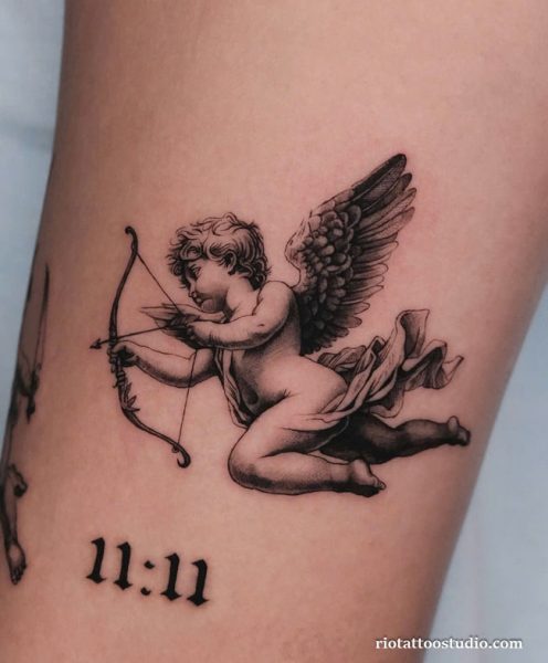 Cherub angel tattoo with bow and 11:11 on forearm, symbolic cute angel tattoo