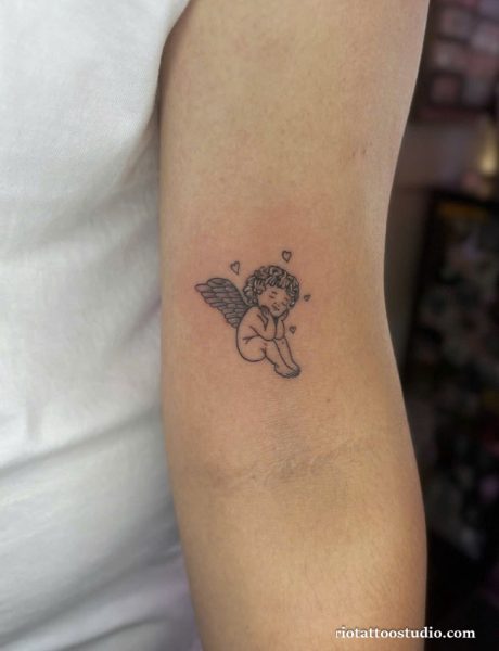Small cherub angel tattoo with hearts on inner arm, delicate cute angel tattoo