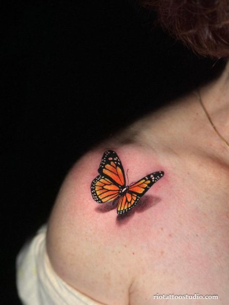 Realistic orange monarch butterfly on shoulder with detailed wings, classic butterfly tattoo