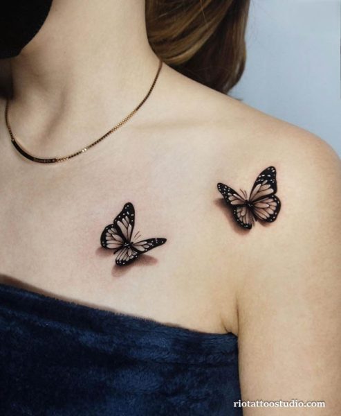Two realistic black butterflies with detailed wings on upper chest, 3D shaded butterfly tattoos