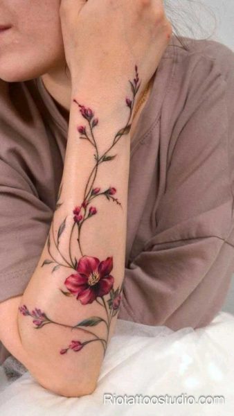 Realistic bougainvillea flowers in pink-purple on shoulder and arm, feminine floral tattoo design
