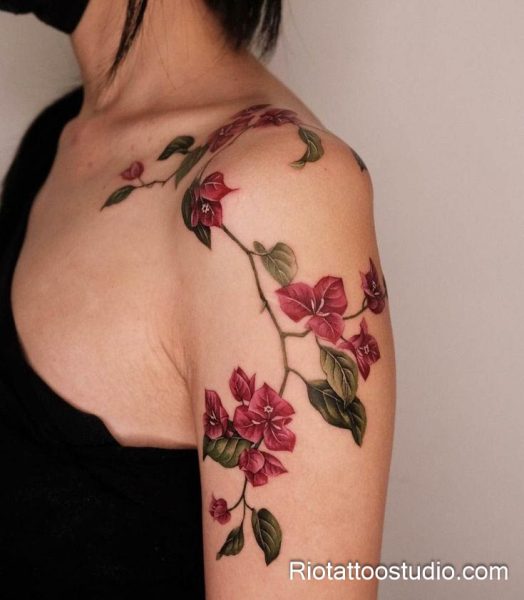 Elegant red flower vine with green leaves on forearm, minimalist feminine tattoo