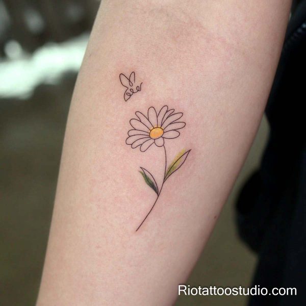 Yellow narcissus flower with green stems on forearm, elegant flower tattoo