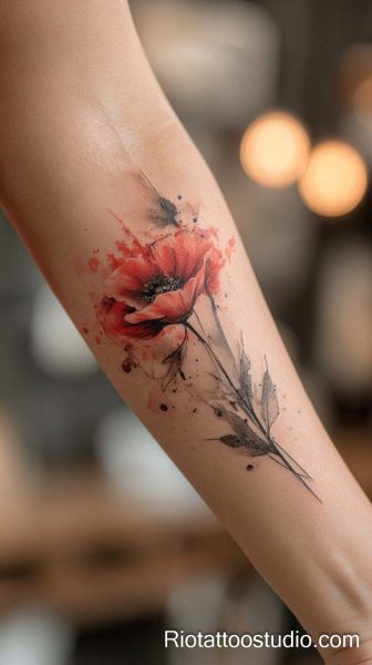 Orange-red watercolor flower with abstract branches on forearm, artistic floral tattoo
