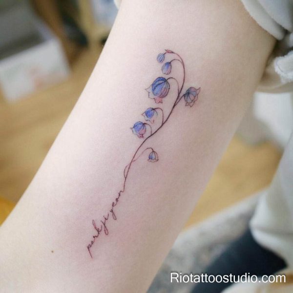 Pink watercolor rose with leaves on forearm, classic feminine flower tattoo