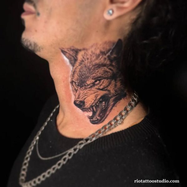 Guy neck tattoo: realistic snarling wolf head on neck, fierce men’s animal tattoo