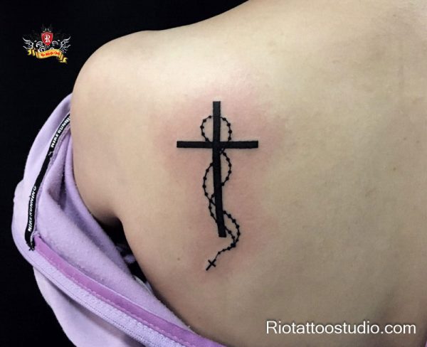 Black cross tattoo with rosary beads on upper back – cross tattoos design