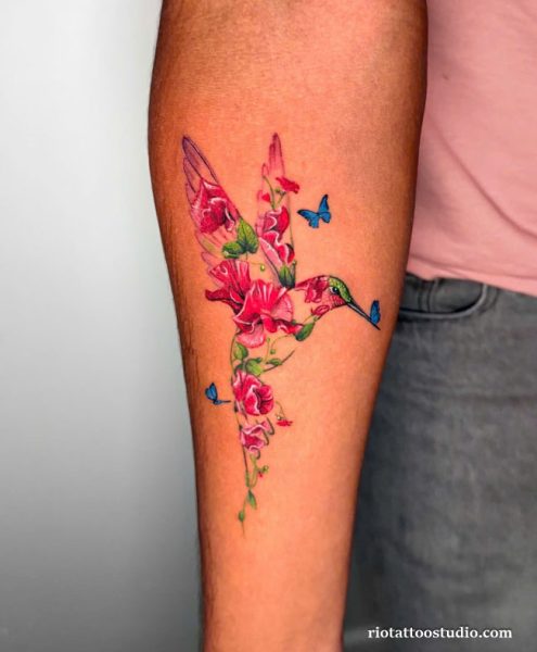 Realistic hummingbird tattoo with pink cherry blossoms on back shoulder, elegant floral hummingbird tattoo