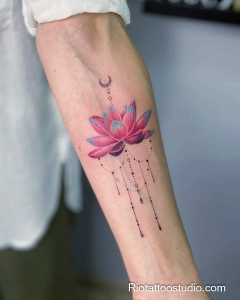 Watercolor pink lotus flower tattoo with moon dots drips on arm, artistic lotus tattoo