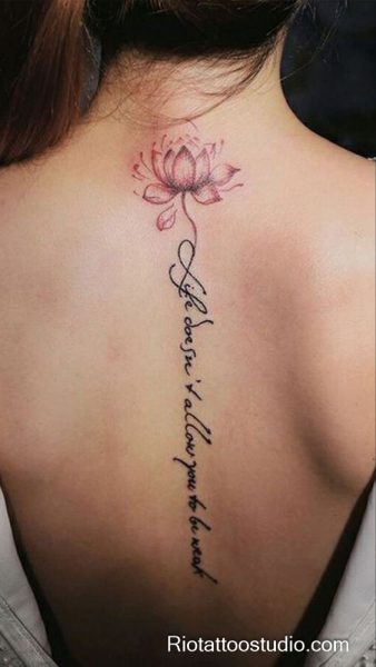 Pink lotus flower tattoo with motivational script on upper back, resilient lotus tattoo