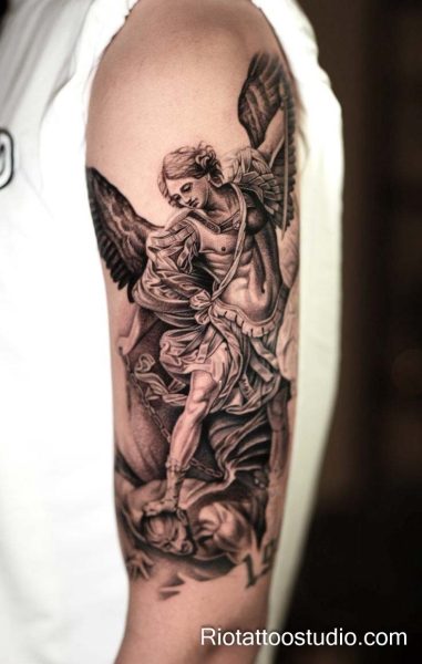 Saint michael archangel tattoo with cross and demon on upper arm, intricate sacred tattoo
