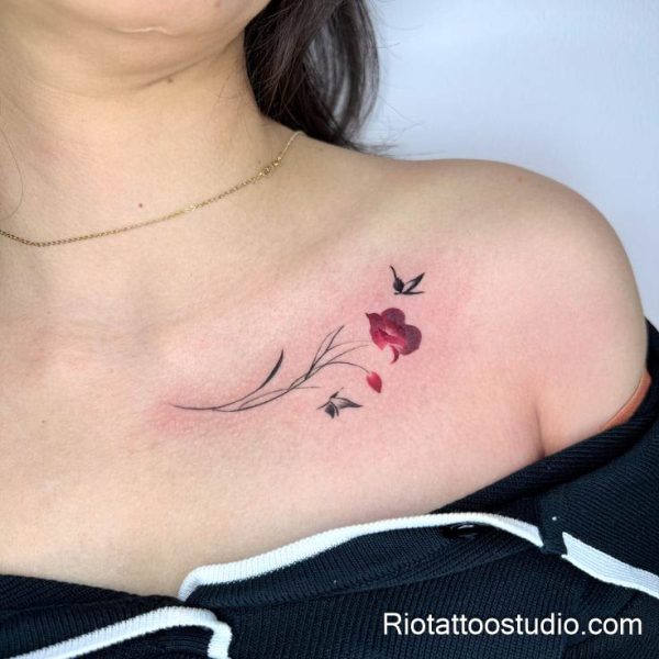 Small red spider lily flowers on side waist, minimalist collarbone-style placement tattoo