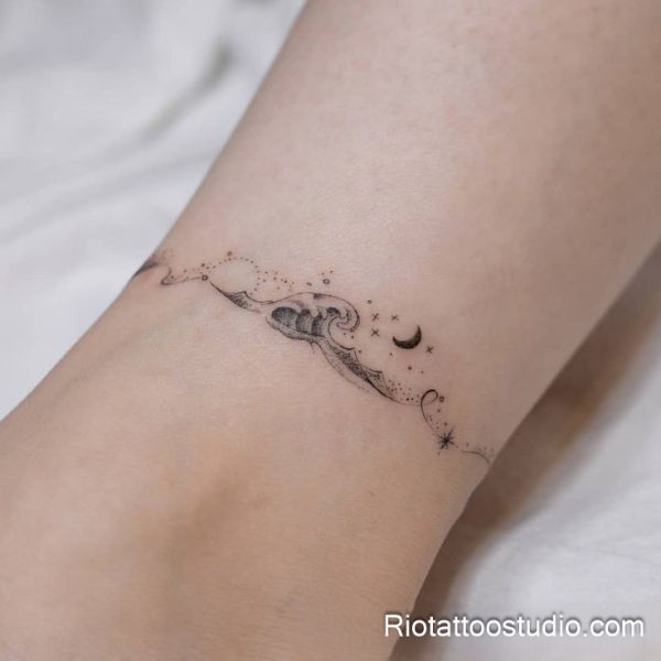 Smallest tattoos: ultra-minimal wave moon star line art on forearm, nature-inspired tiny tattoo