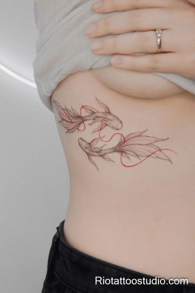 Smallest tattoos: two koi fish in red line art on waist, feminine collarbone-area tattoo