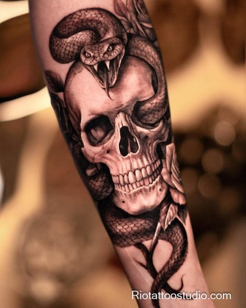 Snake skull tattoo with roses on forearm, realistic skull snake tattoo