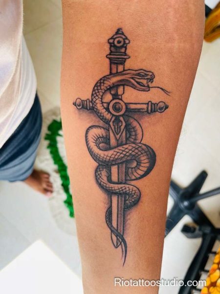 Snake coiled around dagger tattoo on forearm, classic dagger snake tattoo