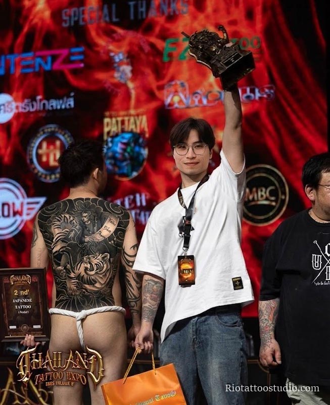 Tattoo Artist Anh Thang receiving second prize for a full back tattoo at Thailand Tattoo Convention