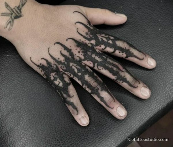 close up of sharp geometric blackwork patterns and solid black bands on knuckles
