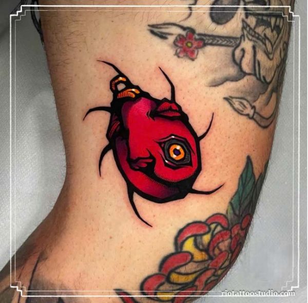 Berserk tattoo colorful behelit egg of the king forearm, symbolic berserk tattoo ideas