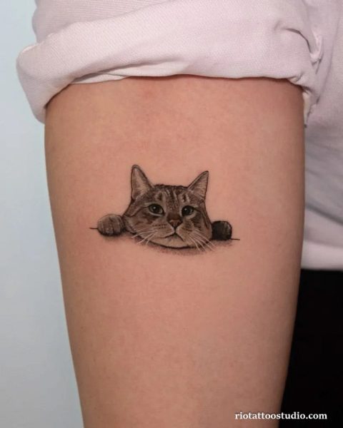 Minimalist cat tattoo peeking over line thigh realistic black grey, cute cat tattoo