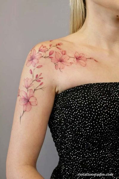 Watercolor falling cherry blossoms forearm tattoo pink petals, soft cherry blossom tattoo