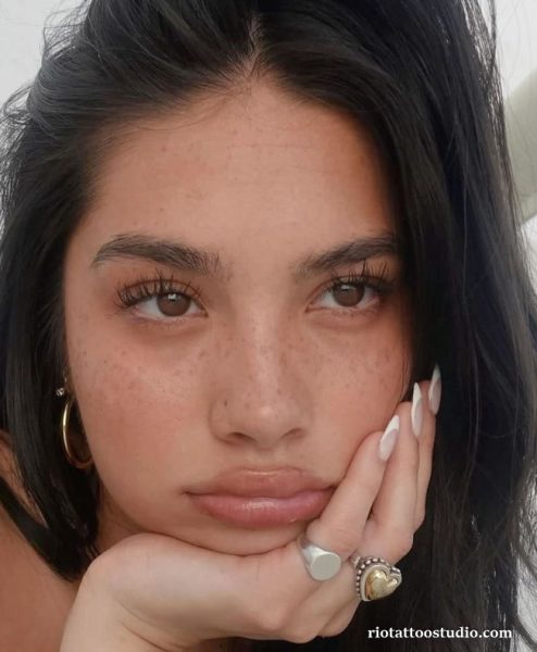 A beautiful, confident girl embracing her natural charm with professional freckles tattoo, highlighting how they enhance her facial beauty.