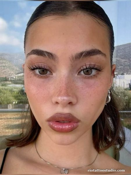 A bold and confident girl showcasing her unique personality with an artistic freckles tattoo custom-designed at Rio Tattoo Studio.