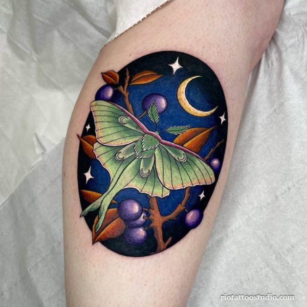 Luna moth tattoo in circular frame with night sky and berries on arm, celestial moth tattoo ideas