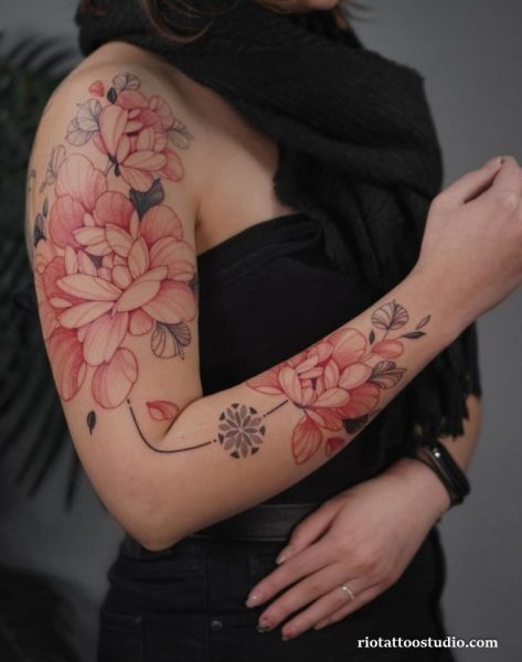 Large colorful peony tattoo sleeve on arm and shoulder with black background, bold peony tattoo ideas