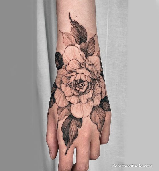 Black and gray peony tattoo covering the back of the hand and wrist, realistic peony tattoo ideas