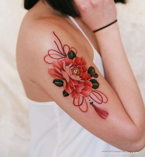 Red peony tattoo with ribbons and tassel on upper arm and shoulder, vibrant peony tattoo ideas