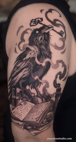 Mystical Raven Tattoo with a key and ancient book design at Rio Tattoo Studio.
