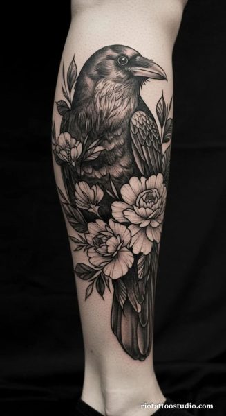 Artistic Raven Tattoo with peony flowers on the upper arm at Rio Tattoo Studio.