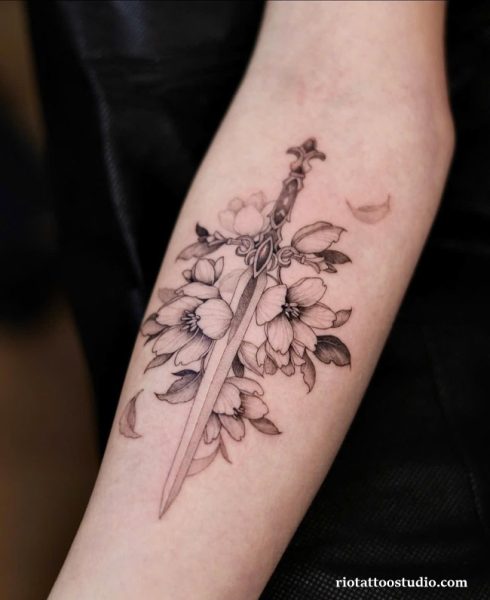 Sword tattoo with cherry blossoms on upper arm, floral sword tattoo ideas