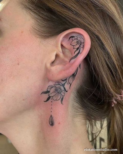 Floral ear tattoos with flowers behind and below the ear plus teardrop, feminine ear tattoos ideas