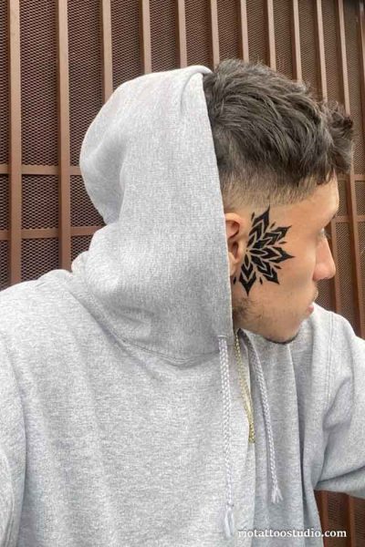 Geometric mandala ear tattoos behind the ear on a man with hoodie, modern ear tattoos ideas