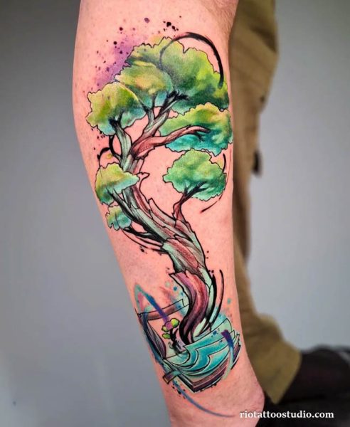 Colorful watercolor tree tattoo with twisted trunk and abstract waves on arm, vibrant tree tattoo ideas
