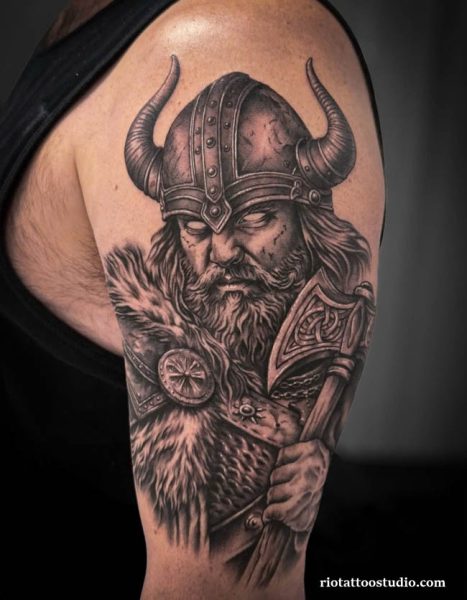 Viking tattoo horned helmet fur axe upper arm realistic black grey, legendary viking tattoo