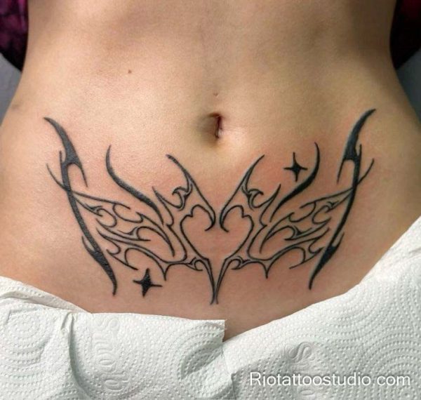 Womb tattoo black tribal symmetrical wings stars lower abdomen, modern womb tattoo ideas
