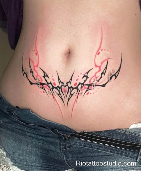 Womb tattoo black pink tribal heart center lower abdomen, bold feminine womb tattoo ideas