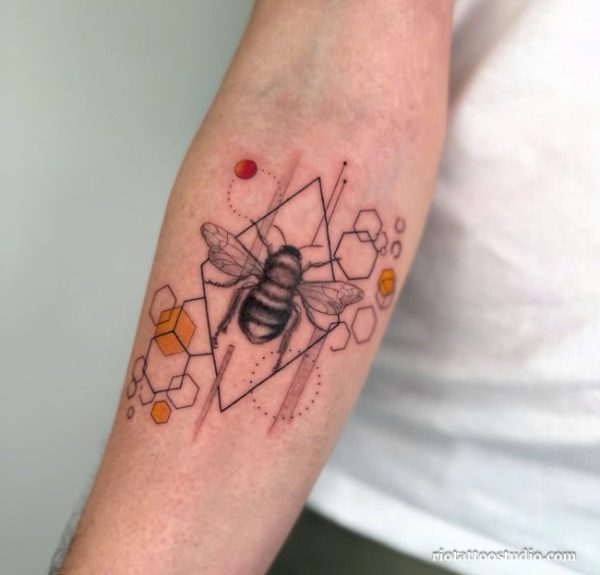 Geometric bee tattoo with honeycomb patterns and orange accents on forearm