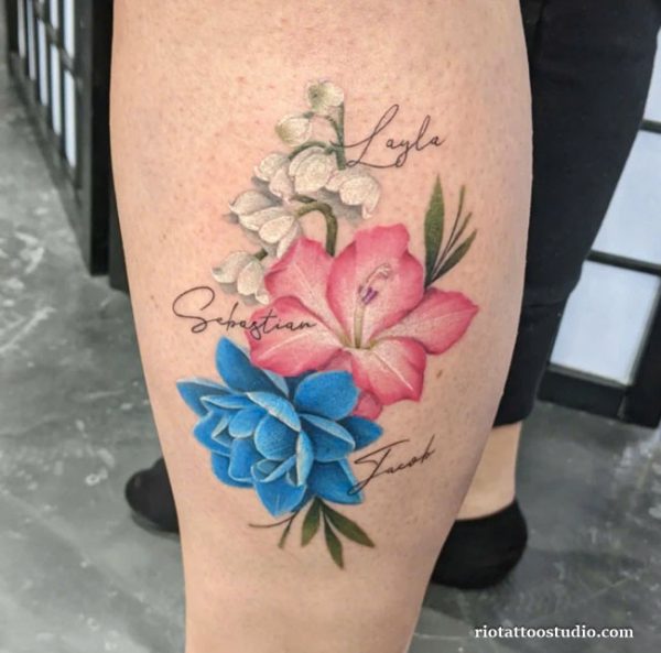 Realistic birth flower tattoo with pink lily, blue hydrangea and white lily of the valley with names on thigh