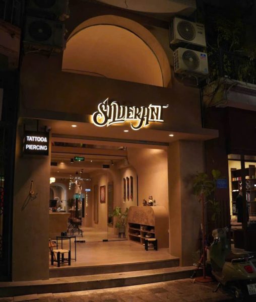 Night view of Silver Ant Tattoo studio entrance in Hanoi with illuminated sign and professional tattoo & piercing setup for coverups tattoo