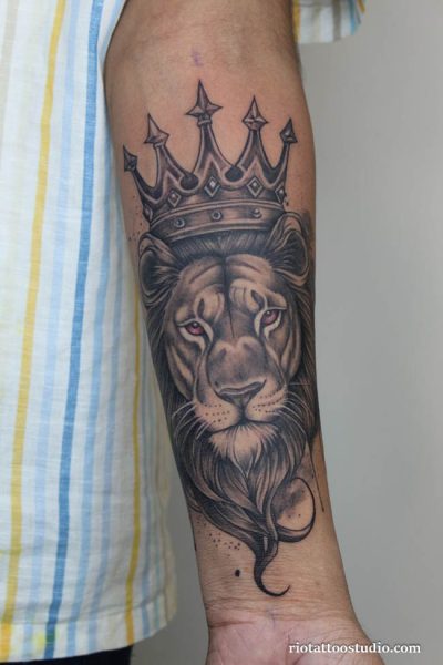 Realistic lion with detailed crown tattoo on guy’s upper arm, powerful crown tattoo ideas