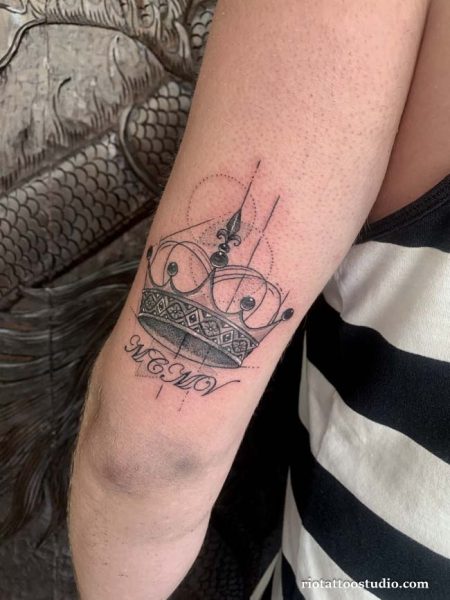 Minimalist crown with geometric lines and script tattoo on inner arm, elegant crown tattoo ideas