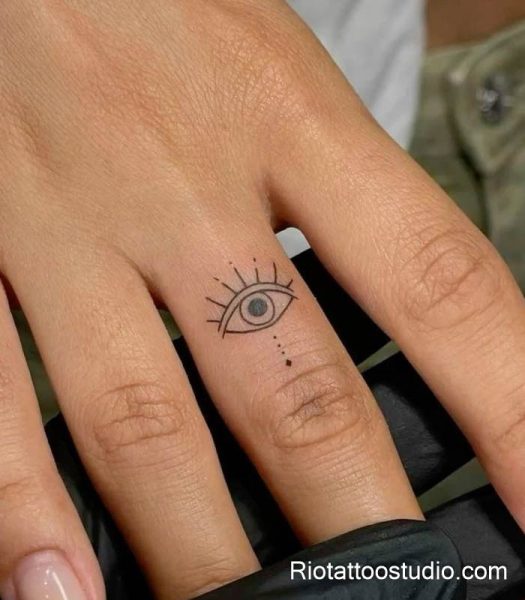 Detailed Hamsa hand tattoo with an evil eye at the palm, featuring intricate dotwork and floral patterns on the shoulder.