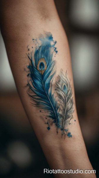 Blue peacock feather tattoo with eye spot and watercolor splashes on arm, peacock feather tattoo ideas