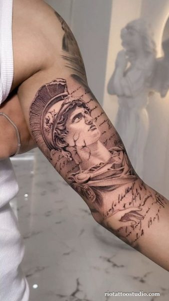 Classical statue half sleeve tattoo with Greek helmet, cracked marble effect and handwritten script on upper arm