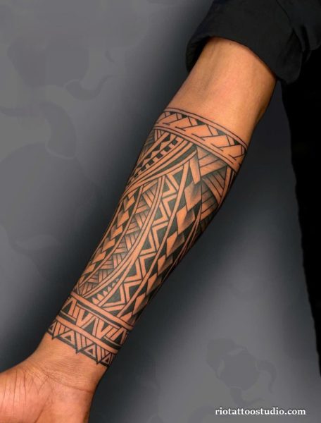 Polynesian tribal half sleeve tattoo with traditional geometric patterns on forearm and upper arm